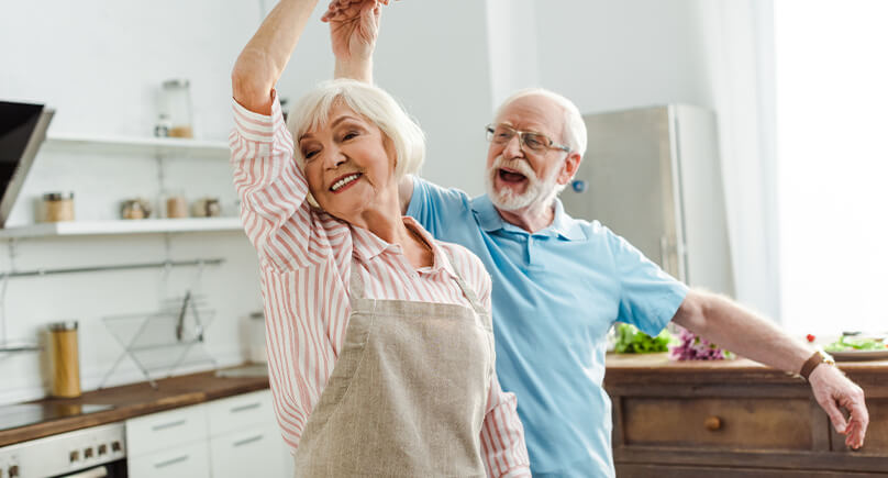 Seniorenpaar tanzt glücklich durch die Küche